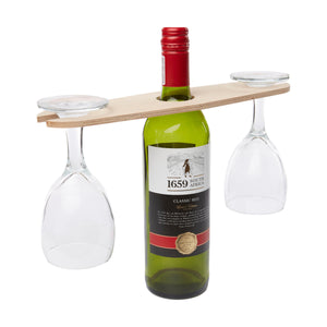 A bottle of wine with the wine balancer on top holding two wine glasses.